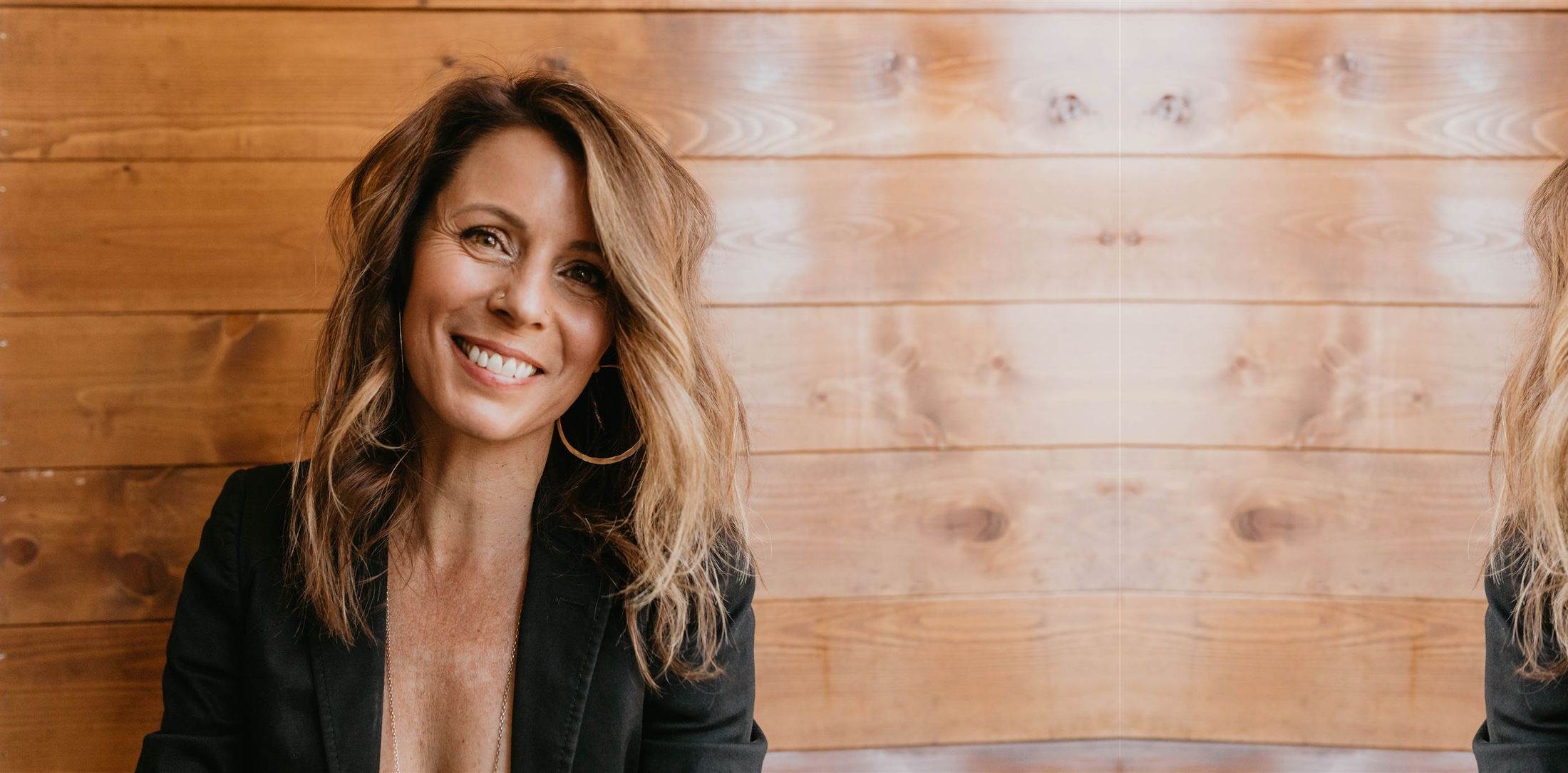 Alexis A. Rosenbaum smiling, against a warm wood wall.